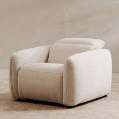 a white recliner chair sitting on top of a carpeted floor next to a wall