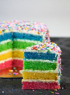 a rainbow cake with one slice cut out