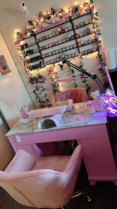 a pink vanity with lights and decorations on the wall behind it, along with a chair