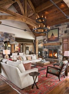 a living room with couches, chairs and a fire place in the middle of it