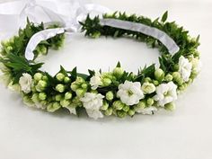 a flower crown with white flowers and green leaves