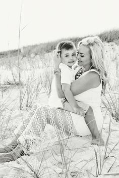 black and white photograph of mother and daughter on the beach with sea oats in background