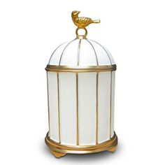 a white bird cage with gold trimmings and a glass dome on the top