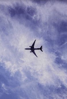 an airplane is flying in the sky with some clouds behind it and blue skies above