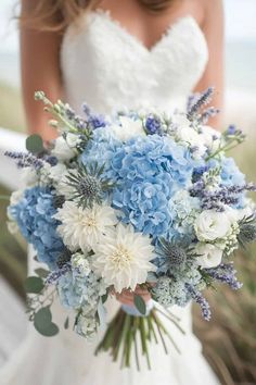 a bride holding a bouquet of blue and white flowers