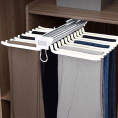 the clothes hanger is attached to the closet door and holds several pairs of pants