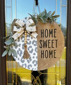 a door hanger that says home sweet home with an animal print bow on it