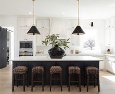 a kitchen island with four stools in front of it