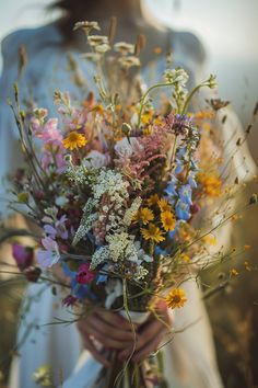 a woman holding a bouquet of flowers in her hands