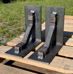 two metal bookends sitting on top of a wooden pallet in the grass