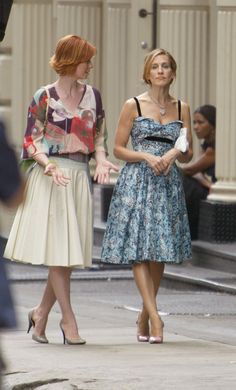 two women walking down the street talking to each other