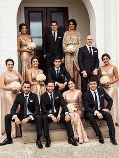 a group of people dressed in formal wear posing for a photo on the steps of a building