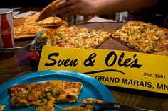 several slices of pizza sitting on top of a blue plate next to a yellow sign