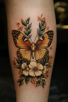 a butterfly with flowers on it's legs is shown in this tattoo art photo