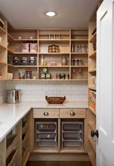 an open pantry with lots of shelves and baskets on the counter top in front of it