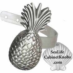 a silver pineapple bottle opener with a shell in the background and sealife label