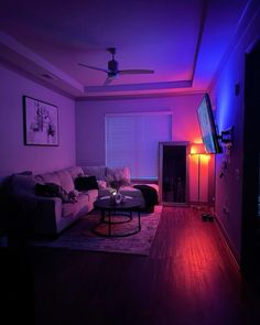 a living room filled with furniture and purple lighting