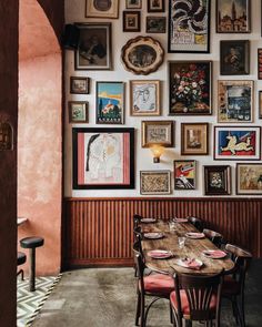 a dining room with many framed pictures on the wall