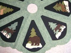 a quilted table top with animals and trees in the center, on a carpet