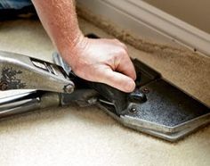 a man is using a pair of pliers to remove carpet