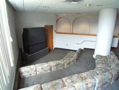 an empty room with couches and a television