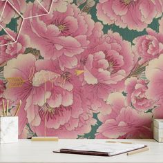 a pink flower wallpaper with gold foil lettering on the front and bottom, next to a white desk