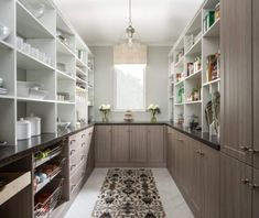 a large kitchen with lots of shelves and cupboards in the center, along with an area rug on the floor