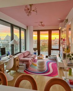 a living room filled with lots of furniture and large windows next to a cityscape