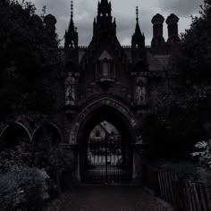 an old building with a gate in front of it on a cloudy day at night