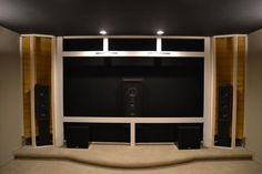 an empty room with speakers on the wall