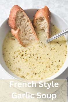 french style garlic soup in a white bowl with two pieces of bread sticking out of it