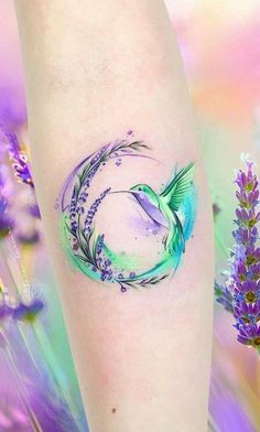 a tattoo on the leg of a woman with purple flowers and lavenders in the background