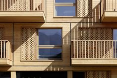 an apartment building with wooden balconies and windows