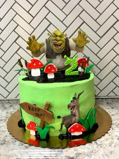 a green cake decorated with an image of a troll