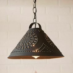 a light fixture hanging from a chain on a brick wall with white bricks in the background