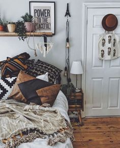 a bedroom with white walls and wooden flooring is decorated with black and white pillows