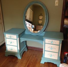 a blue vanity with drawers and a mirror on the wall in a room that has hardwood floors