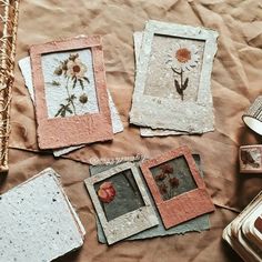 some pictures are laying on top of a table with tin cans and other things around them