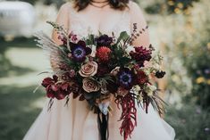 a woman holding a bouquet of flowers in her hands