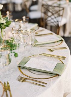 the table is set with gold and white place settings