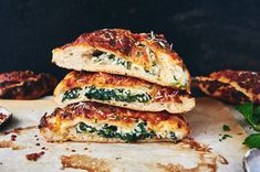 three slices of pizza stacked on top of each other with cheese and spinach toppings