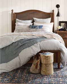 a bed sitting on top of a blue rug next to a wooden headboard and foot board