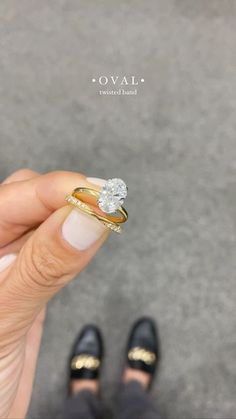 a woman's hand holding a diamond ring in front of her face, with the words ova on it