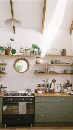 a kitchen with green cabinets and shelves filled with pots, pans and other items