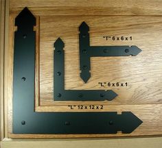 three black arrows pointing in different directions on a wooden surface with measurements for each one