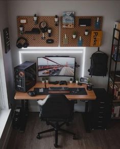 a computer desk with a monitor, keyboard and mouse on it in front of a wall