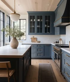 a large kitchen with blue cabinets and white counter tops, along with an area rug on the floor