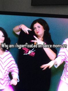 three women are standing in front of a television with one pointing at the other side