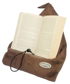 an open book sitting on top of a pillow with a cord attached to the back