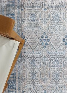 a blue and white rug with a wooden chair next to it